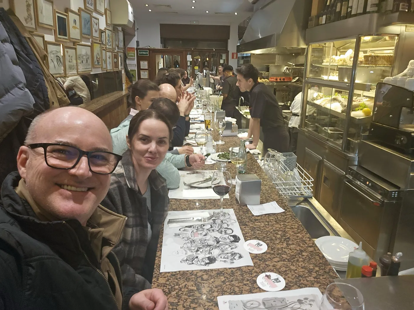 Jason and Heather sitting at the long counter of a busy tapas bar in Barcelona