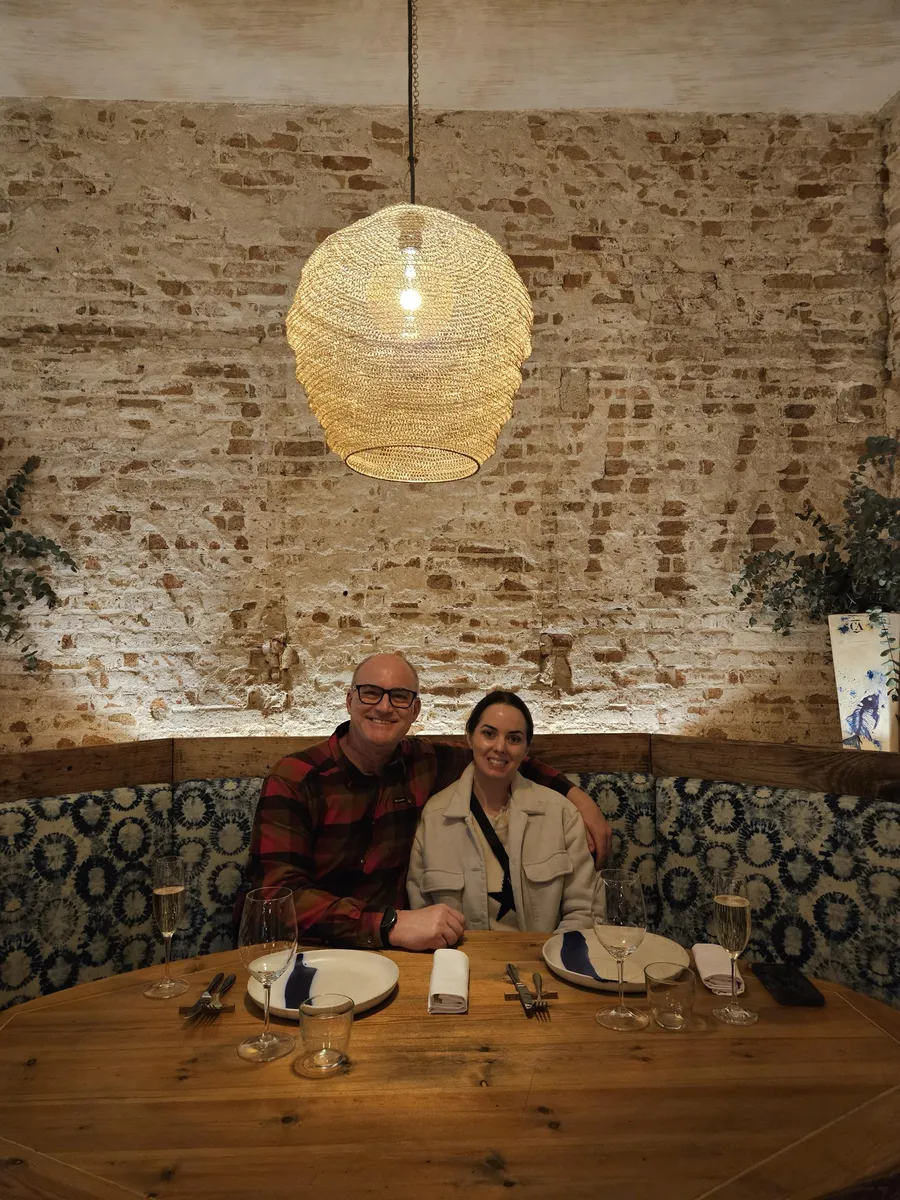 Jason and Heather in a booth with glasses of cava at a Barcelona restaurant