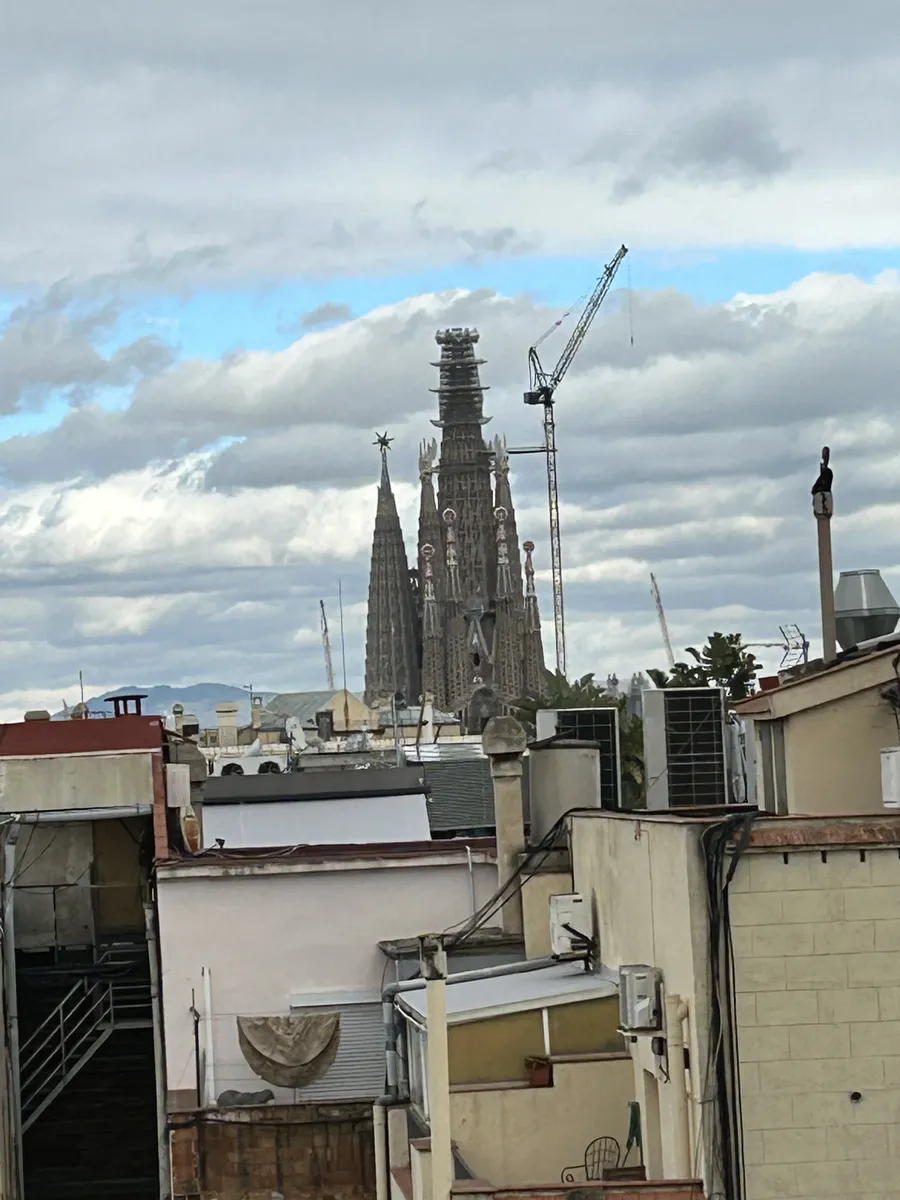 Sagrada Família towers and construction cranes rising above Barcelona rooftops