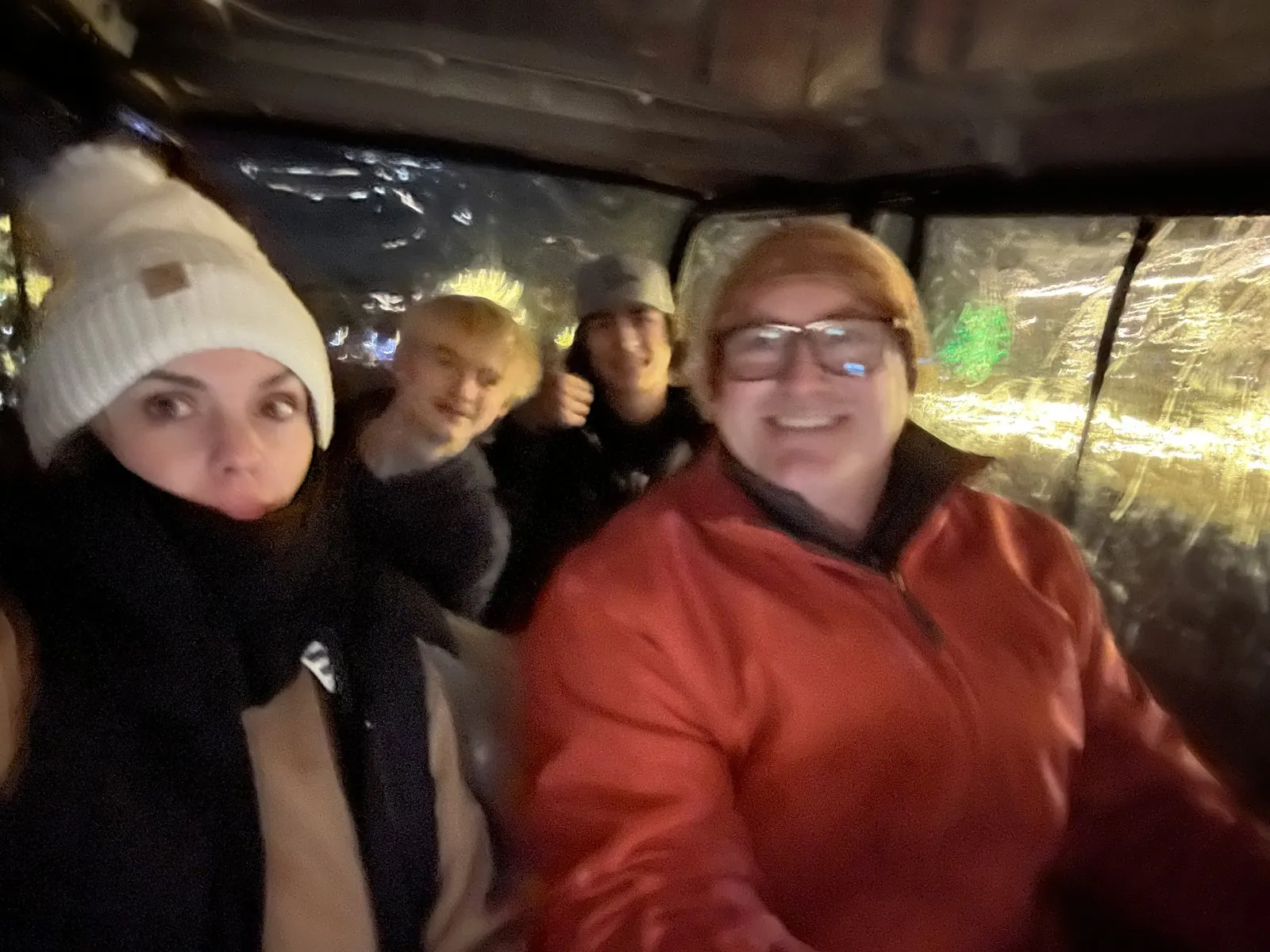 Family bundled up in an enclosed golf cart on the Nature at Night light tour
