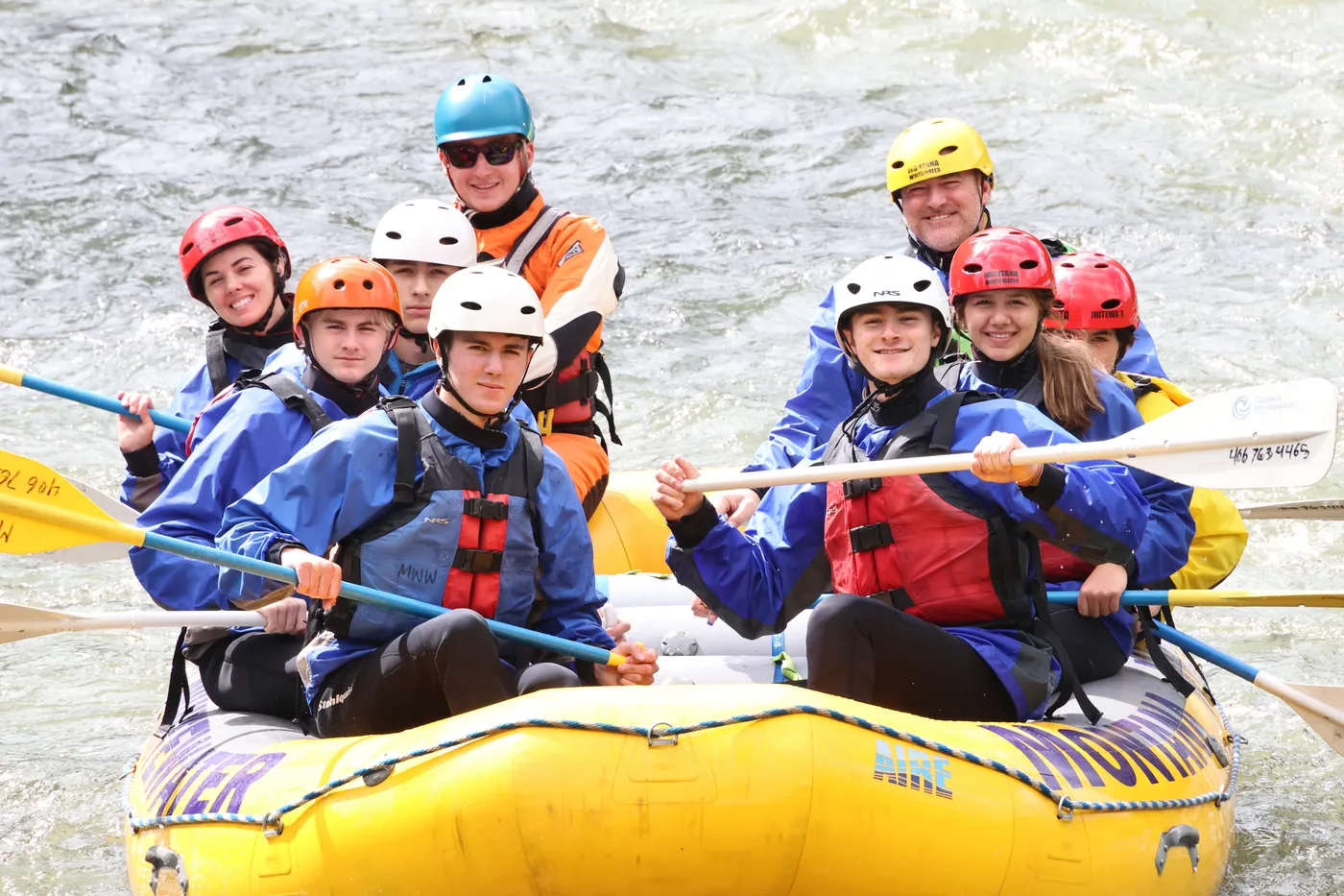 Family whitewater rafting through rapids on the Gallatin River in Montana