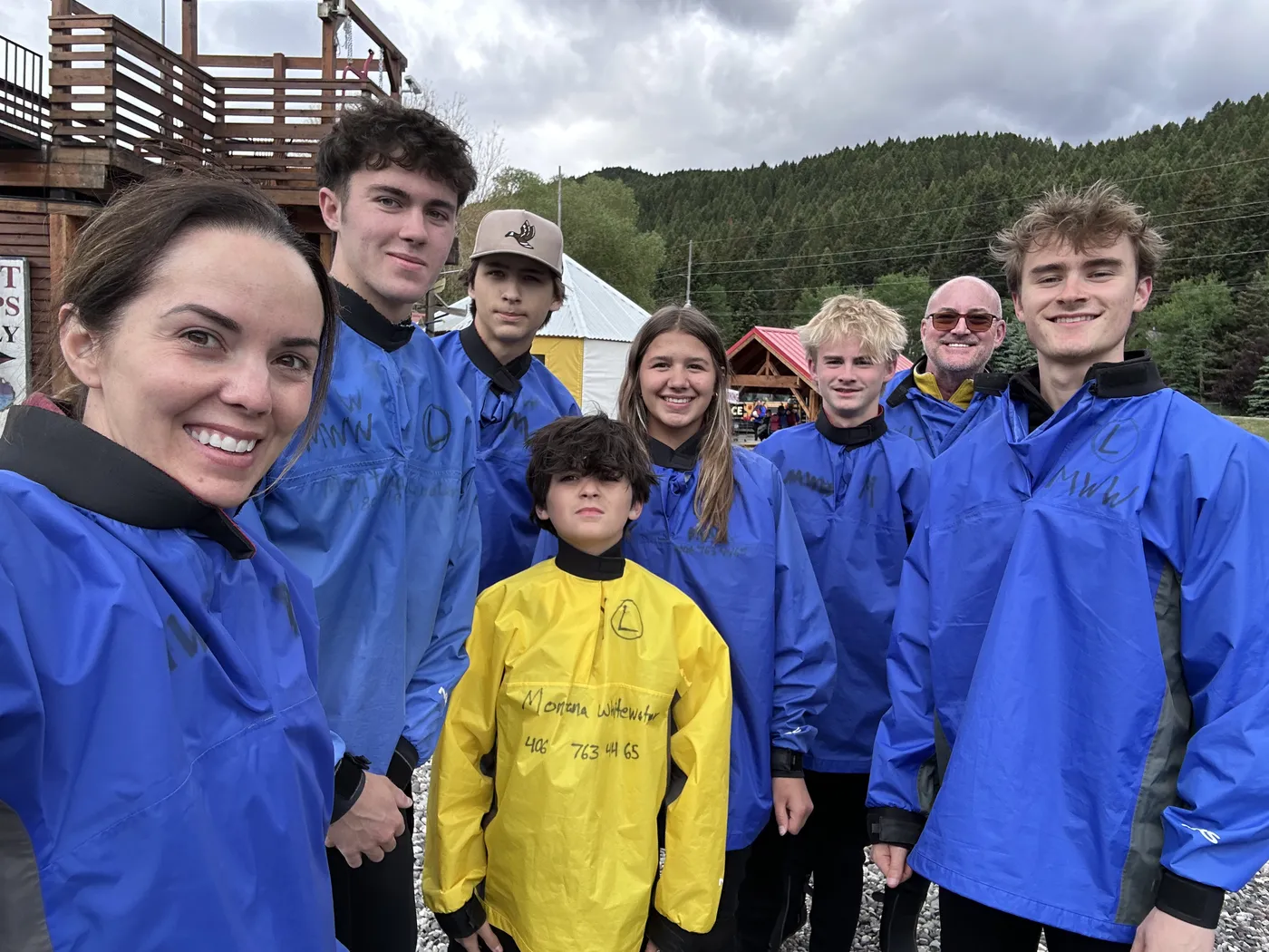 Family in blue splash jackets before a whitewater rafting trip on the Gallatin River