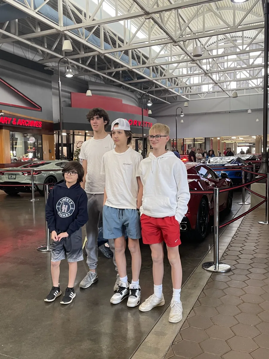 Four boys posing together inside the National Corvette Museum