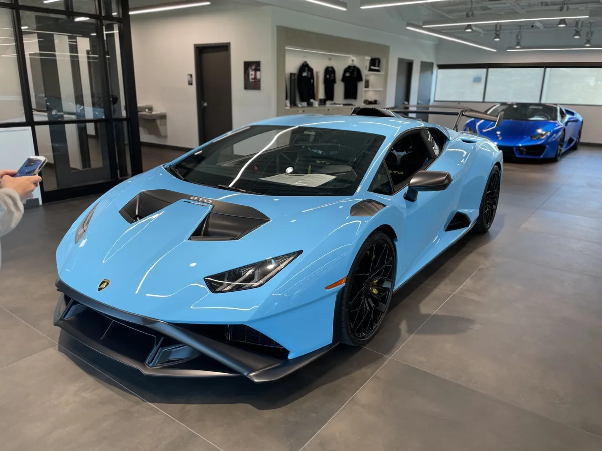A baby-blue Lamborghini Huracán STO in a dealer showroom