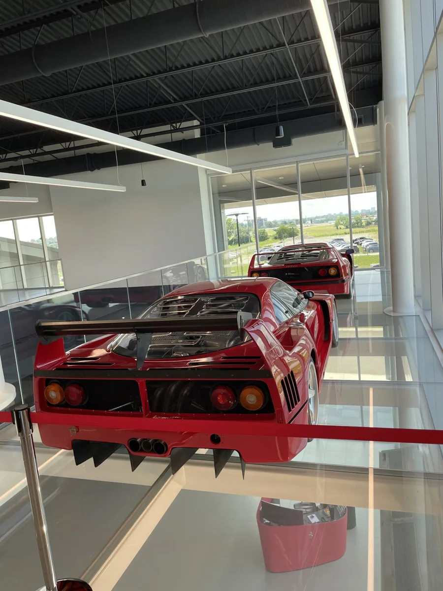 A red Ferrari F40 displayed on a glass mezzanine at Prancing Horse of Nashville