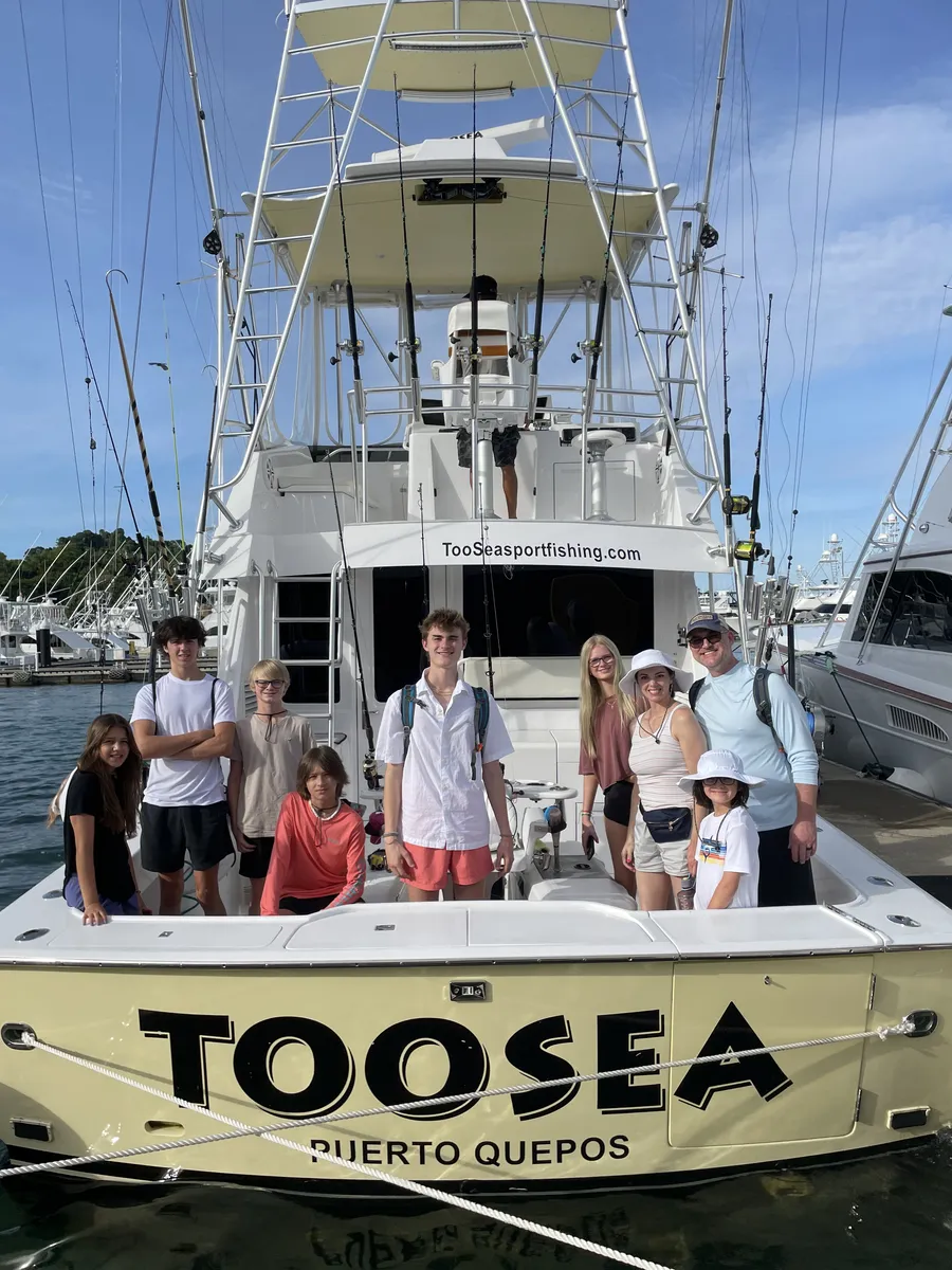 Family standing on the back of a sport fishing boat in Quepos