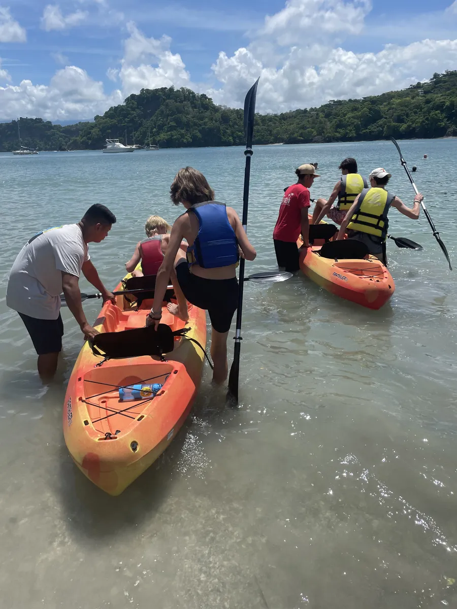 Family launching kayaks from a beach in Costa Rica
