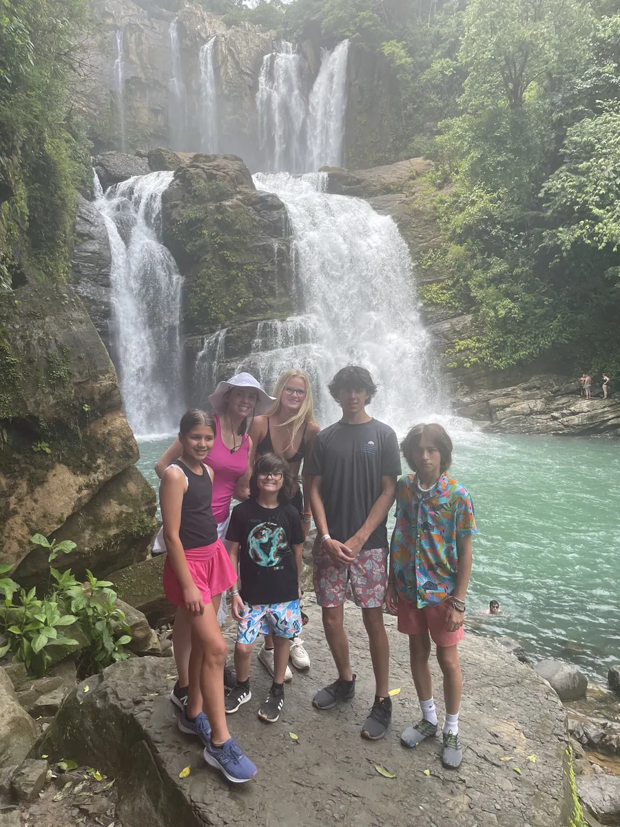 Family posing in front of Nauyaca Waterfalls