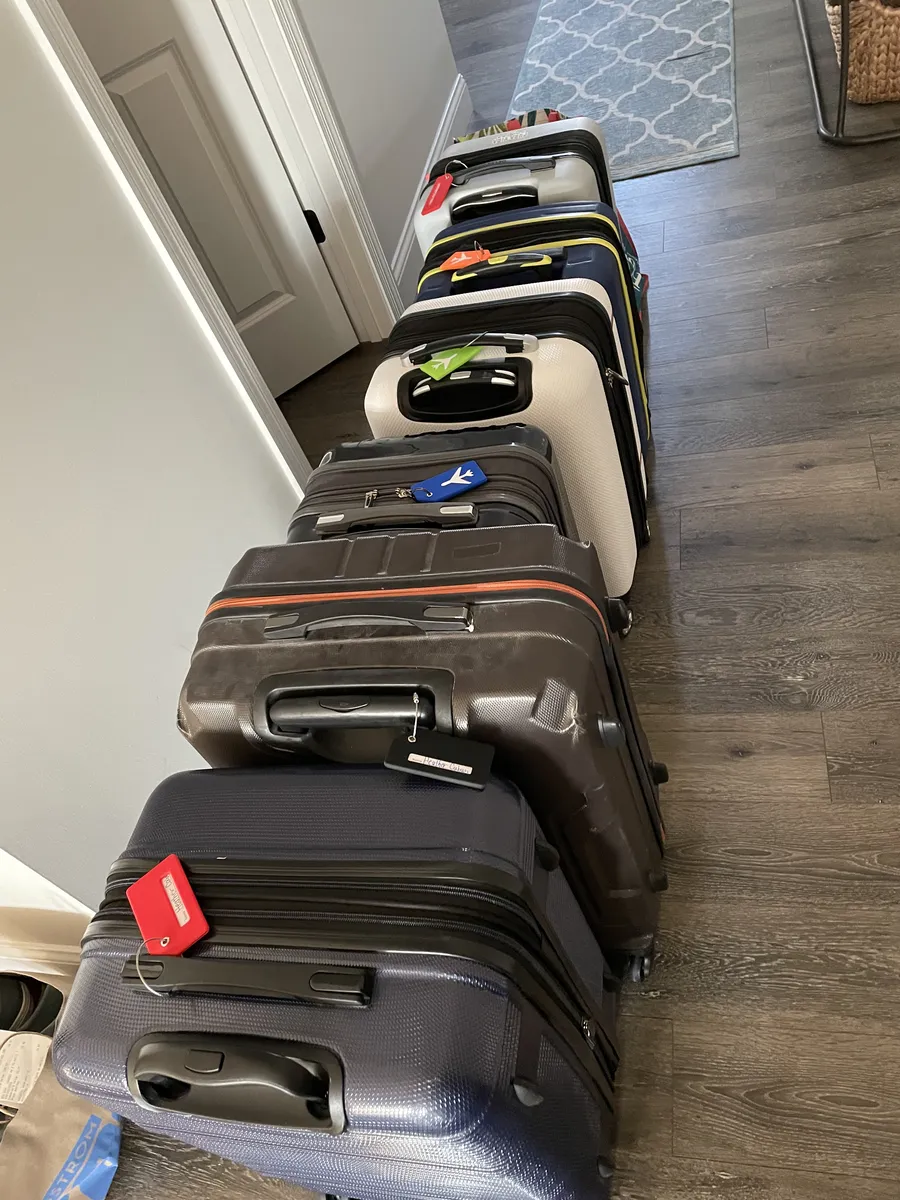 A row of family suitcases lined up in a hallway before a trip