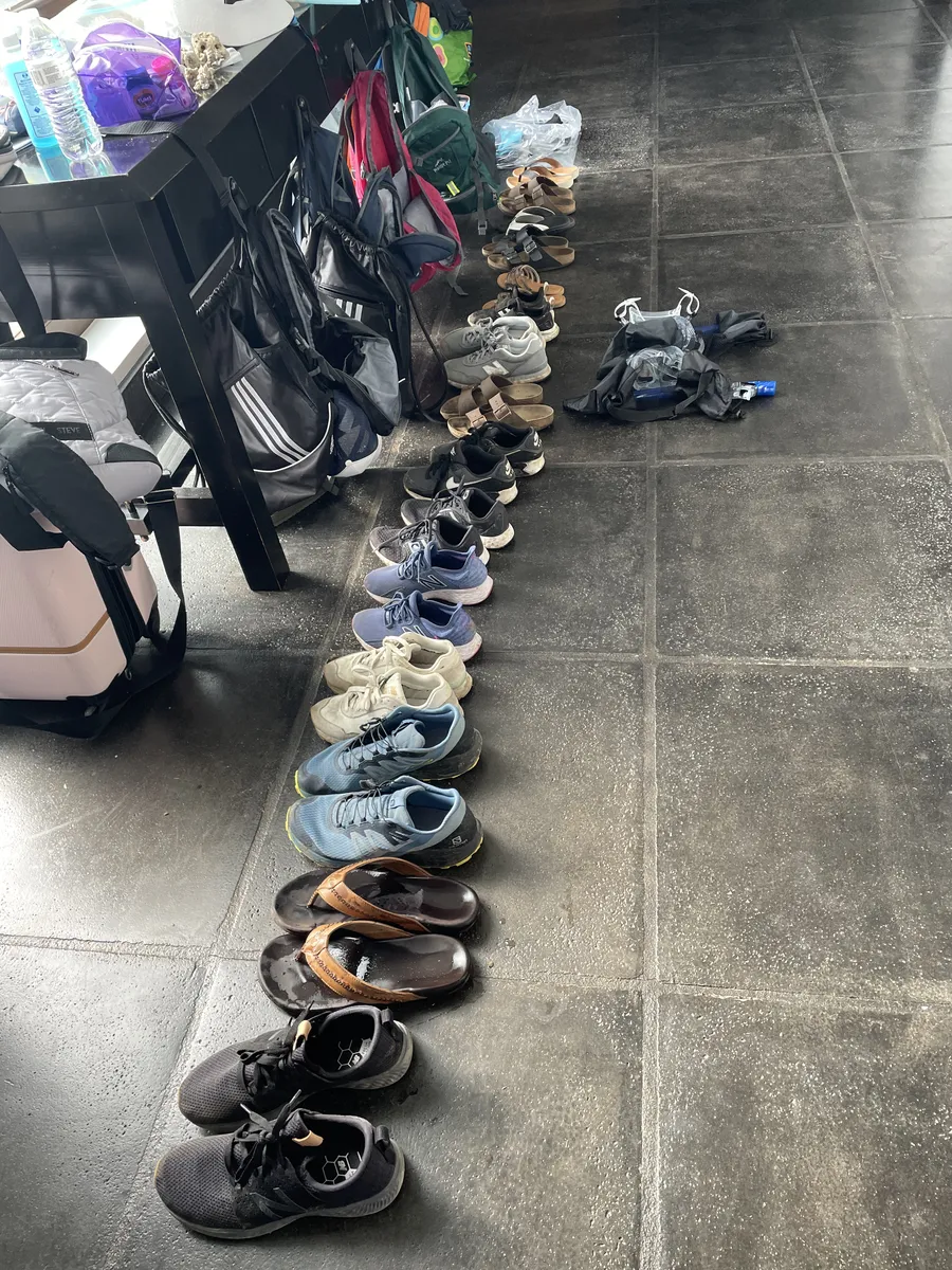 Long row of family shoes lined up on a tile floor