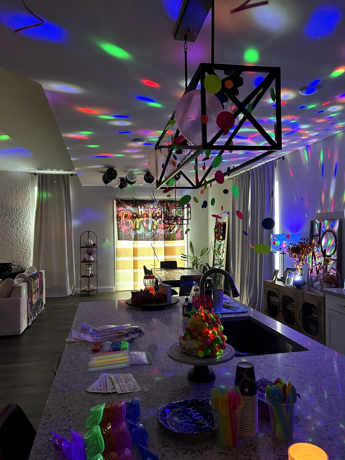 Kitchen and living room with disco ball lights projecting colored dots across the ceiling