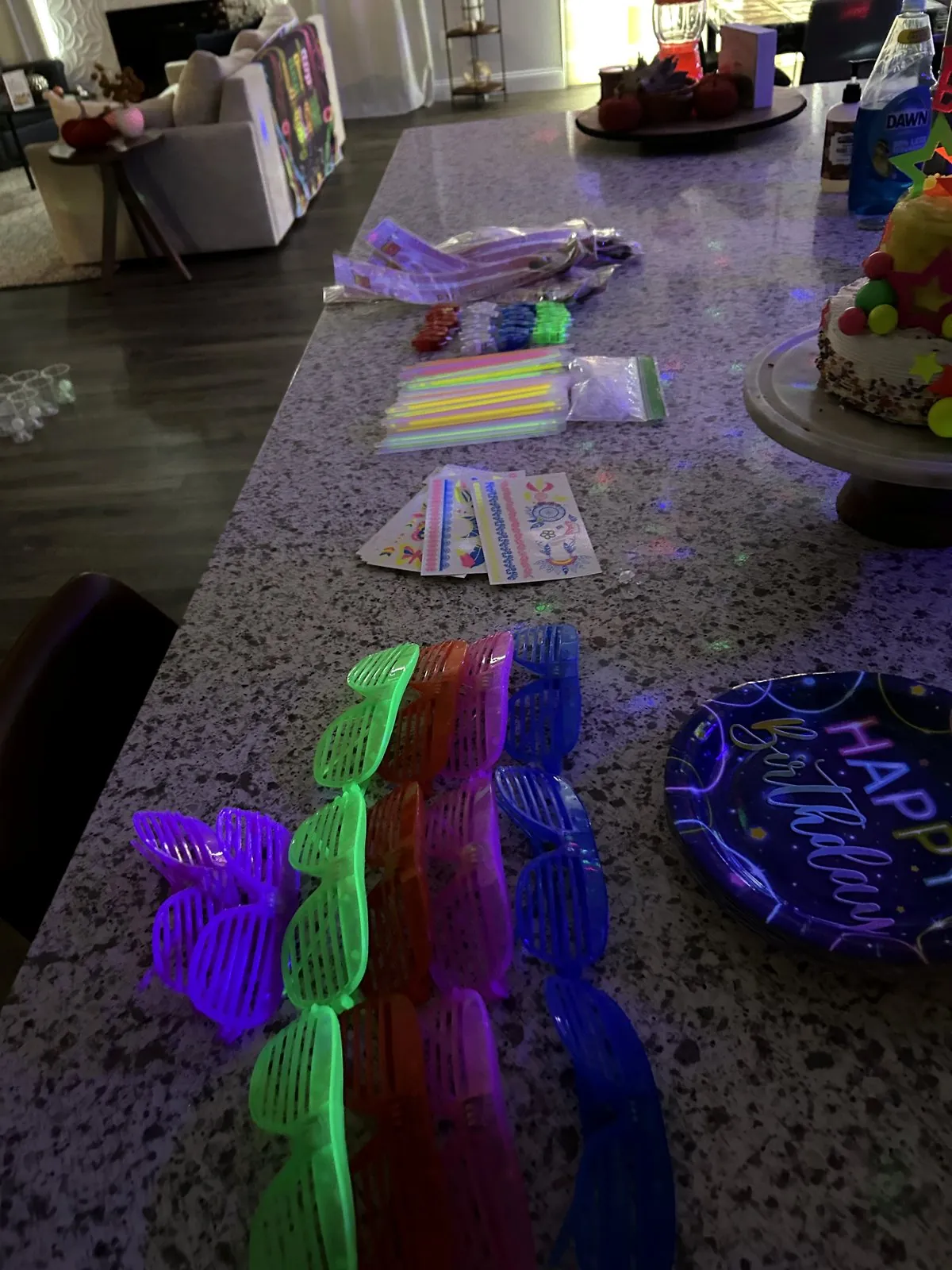 LED shutter glasses, glow stick bracelets and neon birthday plates on the kitchen island