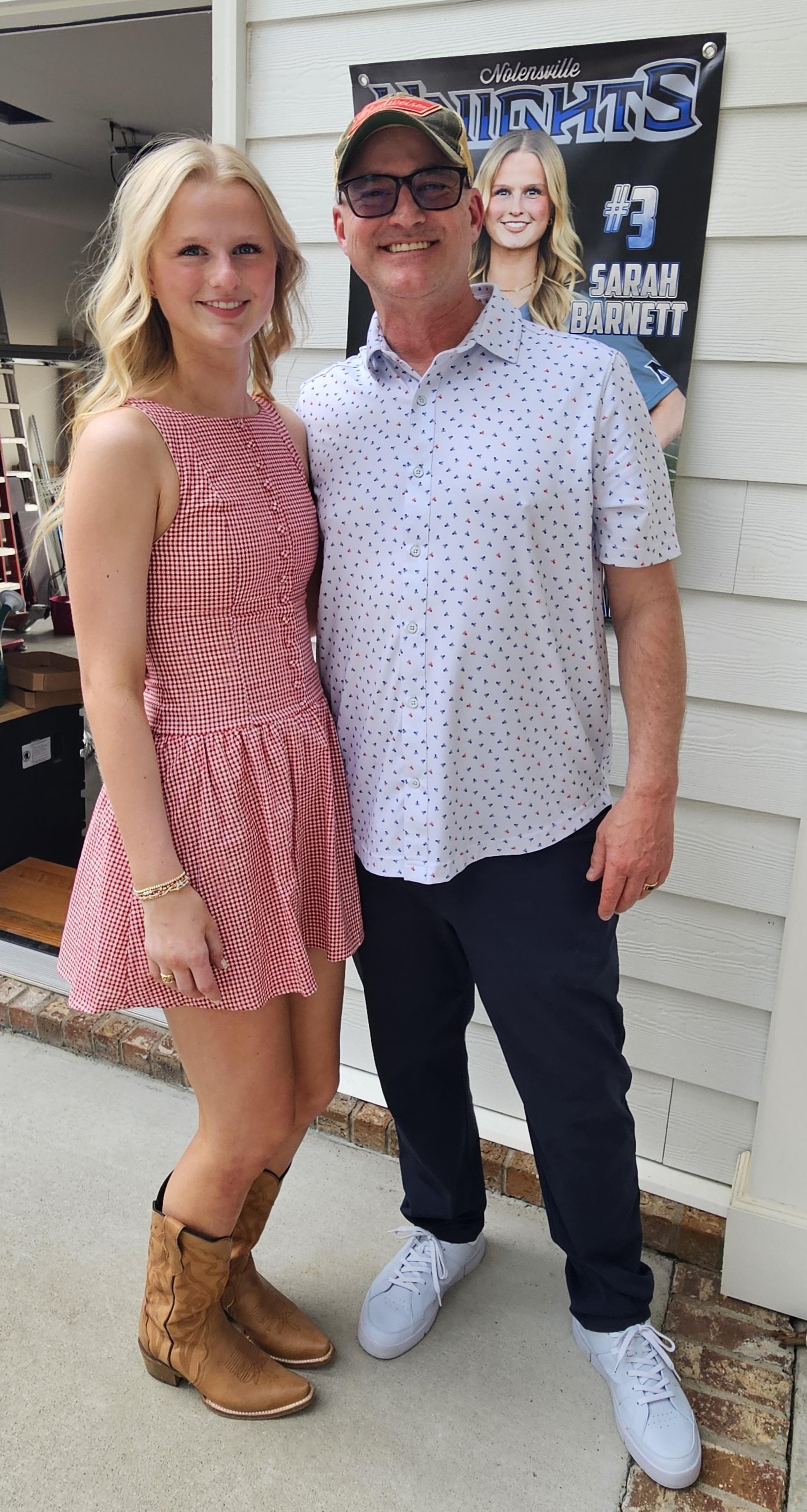 Sarah with her dad on party day, Nolensville Knights #3 banner in the background