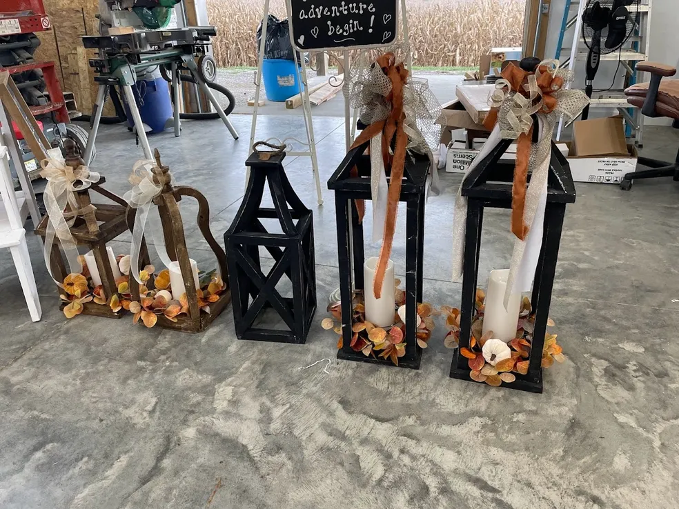 Decorated lanterns with fall ribbon and candles lined up in the workshop