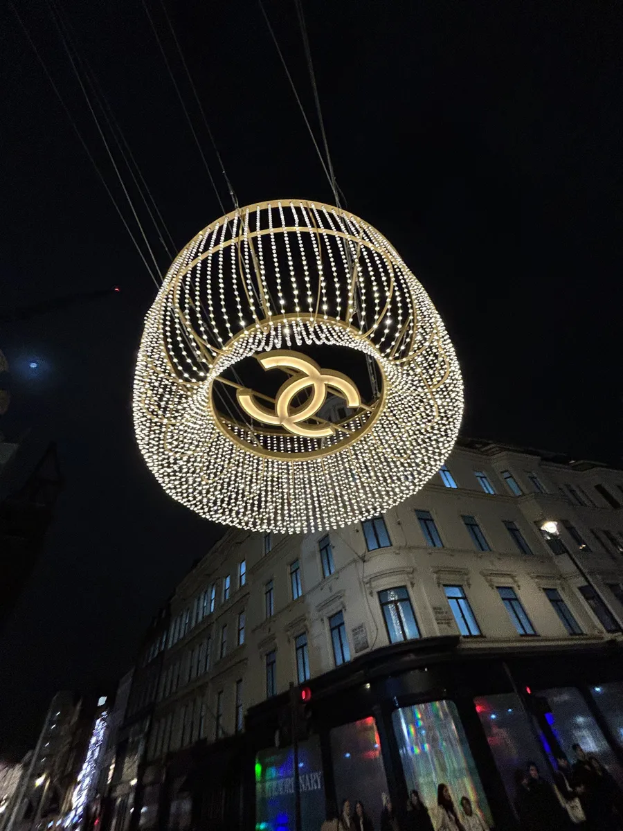 Giant illuminated chandelier with the Chanel logo hanging over a London street at Christmas