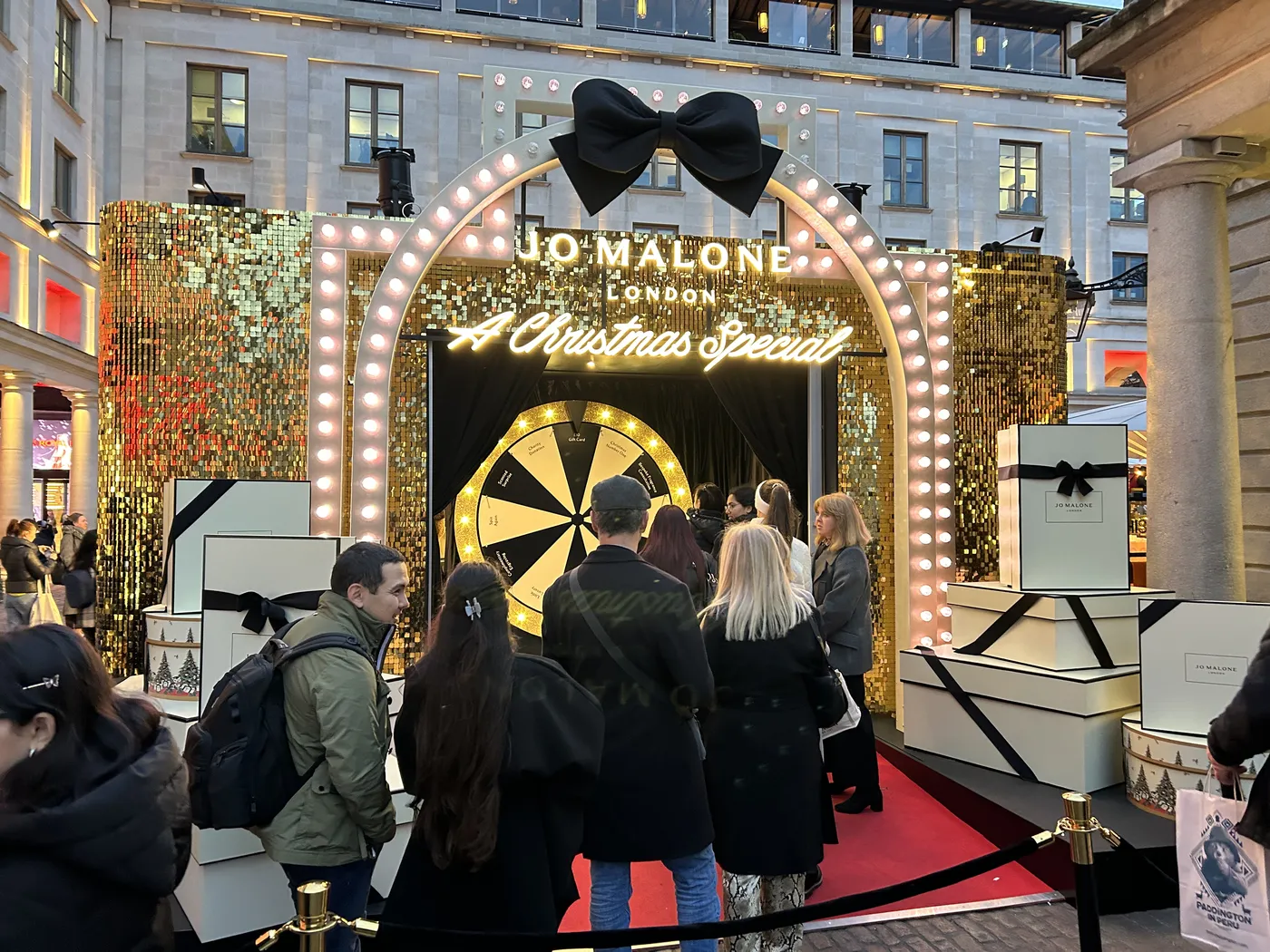 Jo Malone London Christmas pop-up with a giant bow and marquee lights in Covent Garden