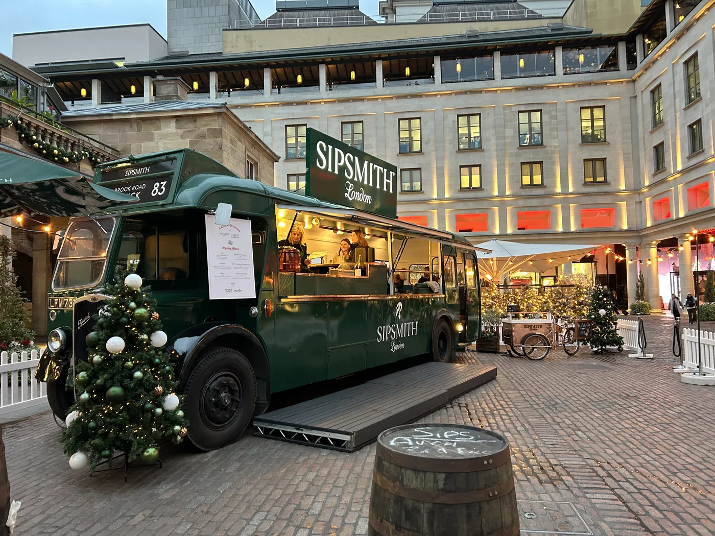 Vintage green Sipsmith gin bus decorated for Christmas in Covent Garden