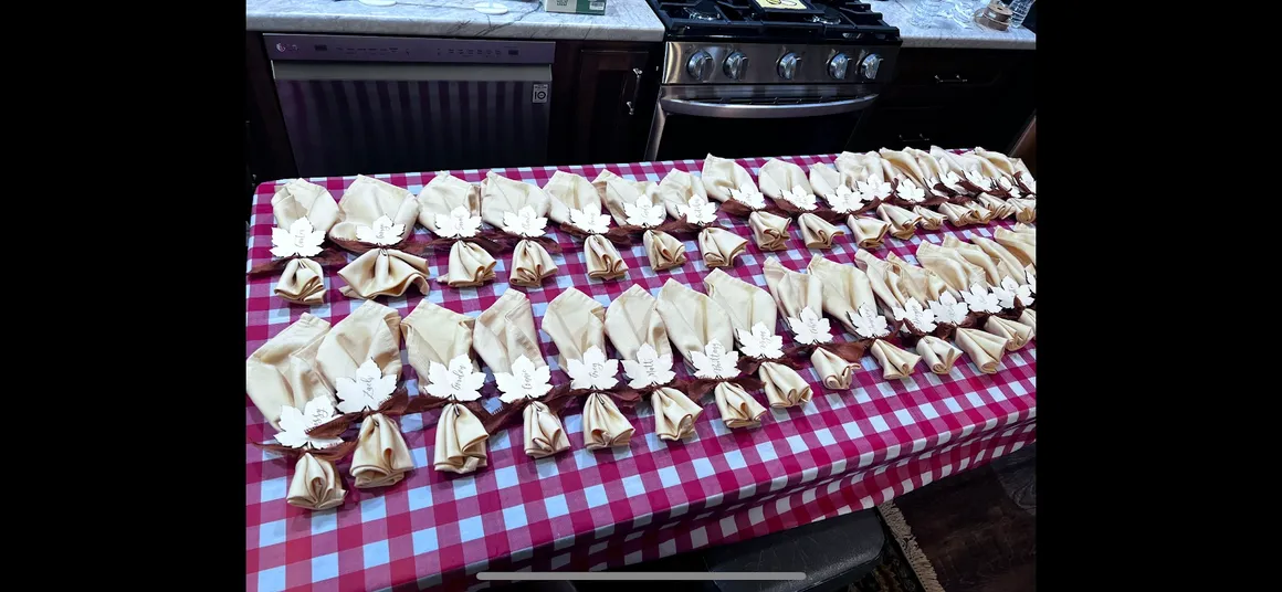 Rows and rows of hand-folded napkins with personalized laser-cut leaf place cards