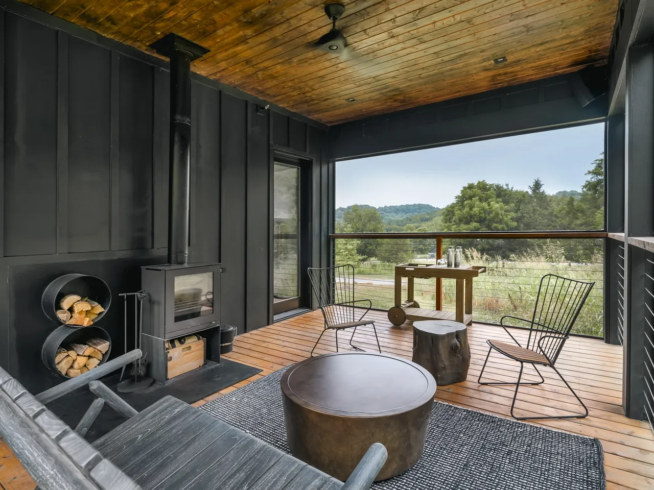 The cottage private outdoor space — wood burning stove, deck chairs, and rolling Tennessee hills in the background